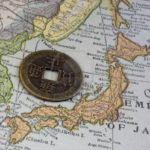 3938923-empire-of-japan-on-a-vintage-map-1926-and-old-japanese-coin-with-square-hole